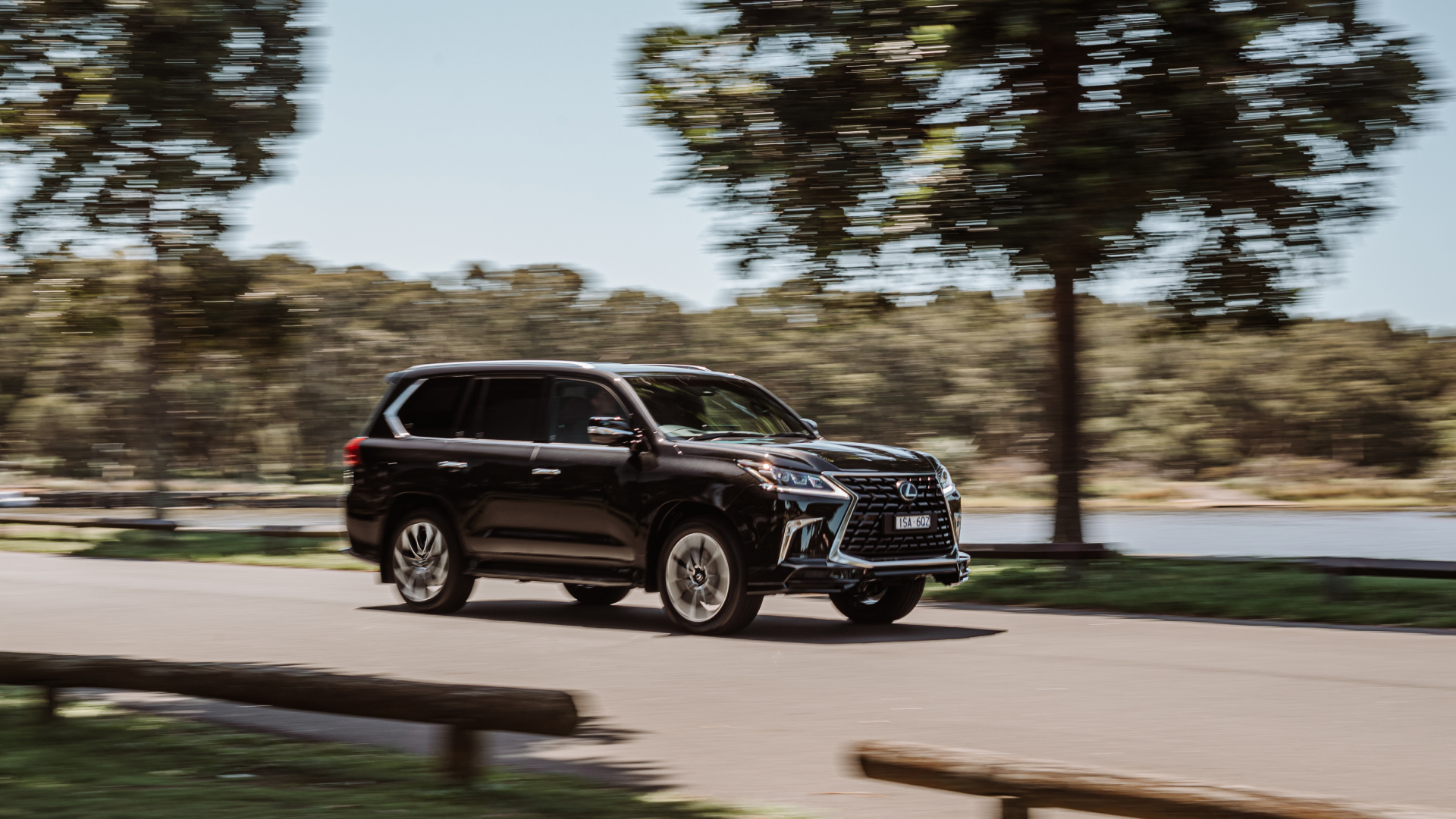 A 2021 Lexus LX 570 S drives along a road at speed.