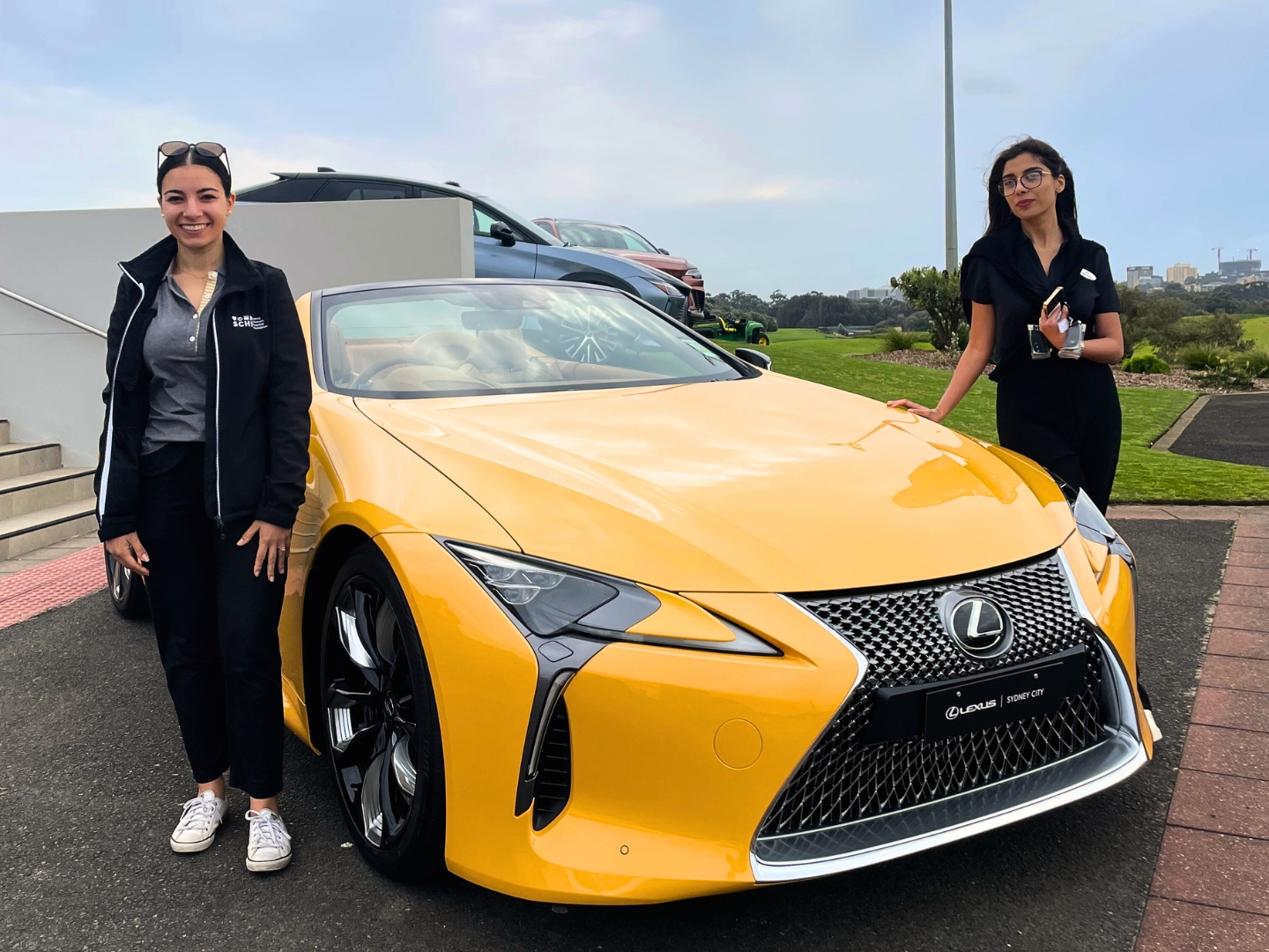 Lexus LC yellow, backdrop of a golf course 