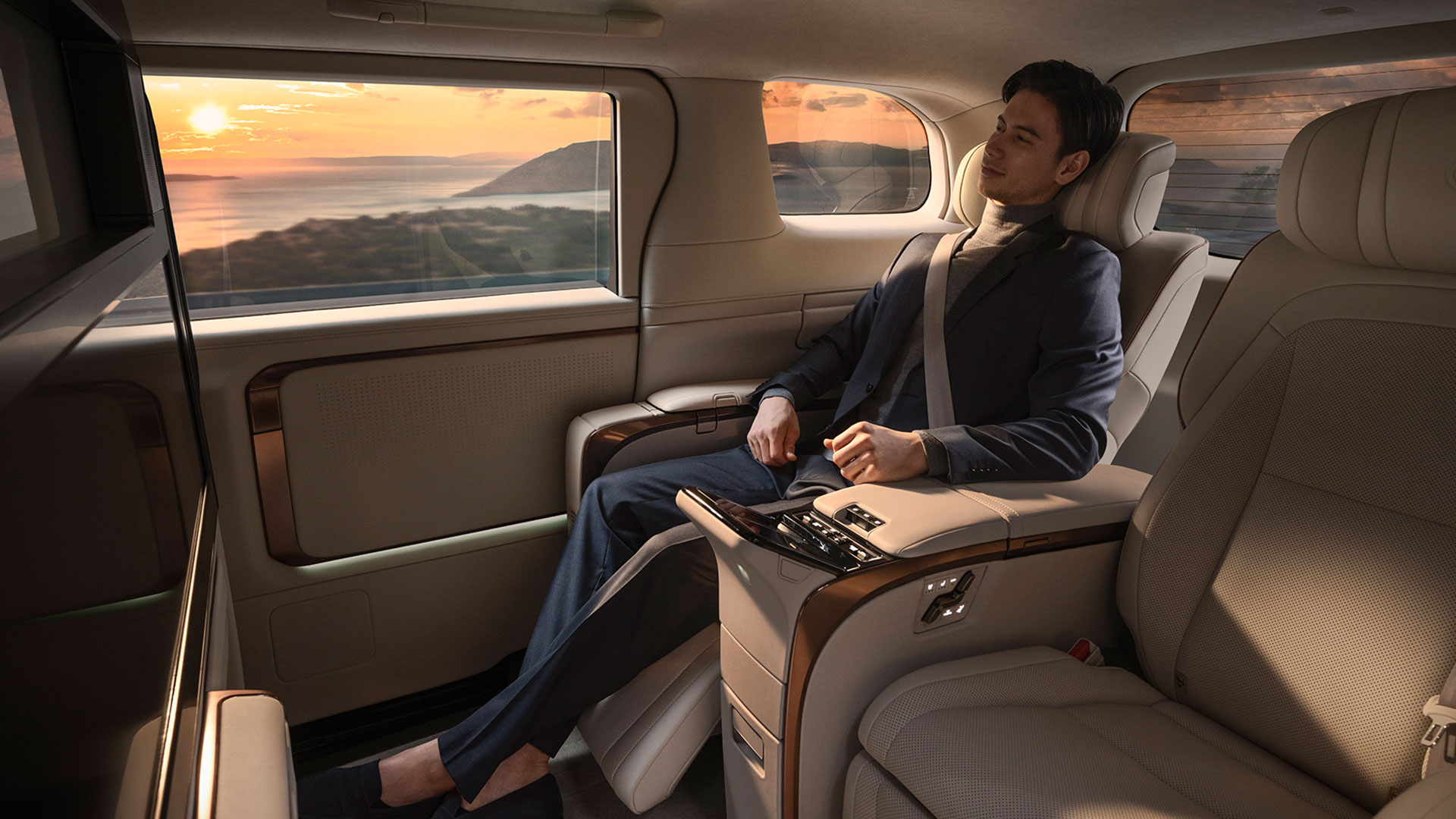 Man enjoys the opulent interior of the Lexus LM rear seats. His legs are stretched out.
