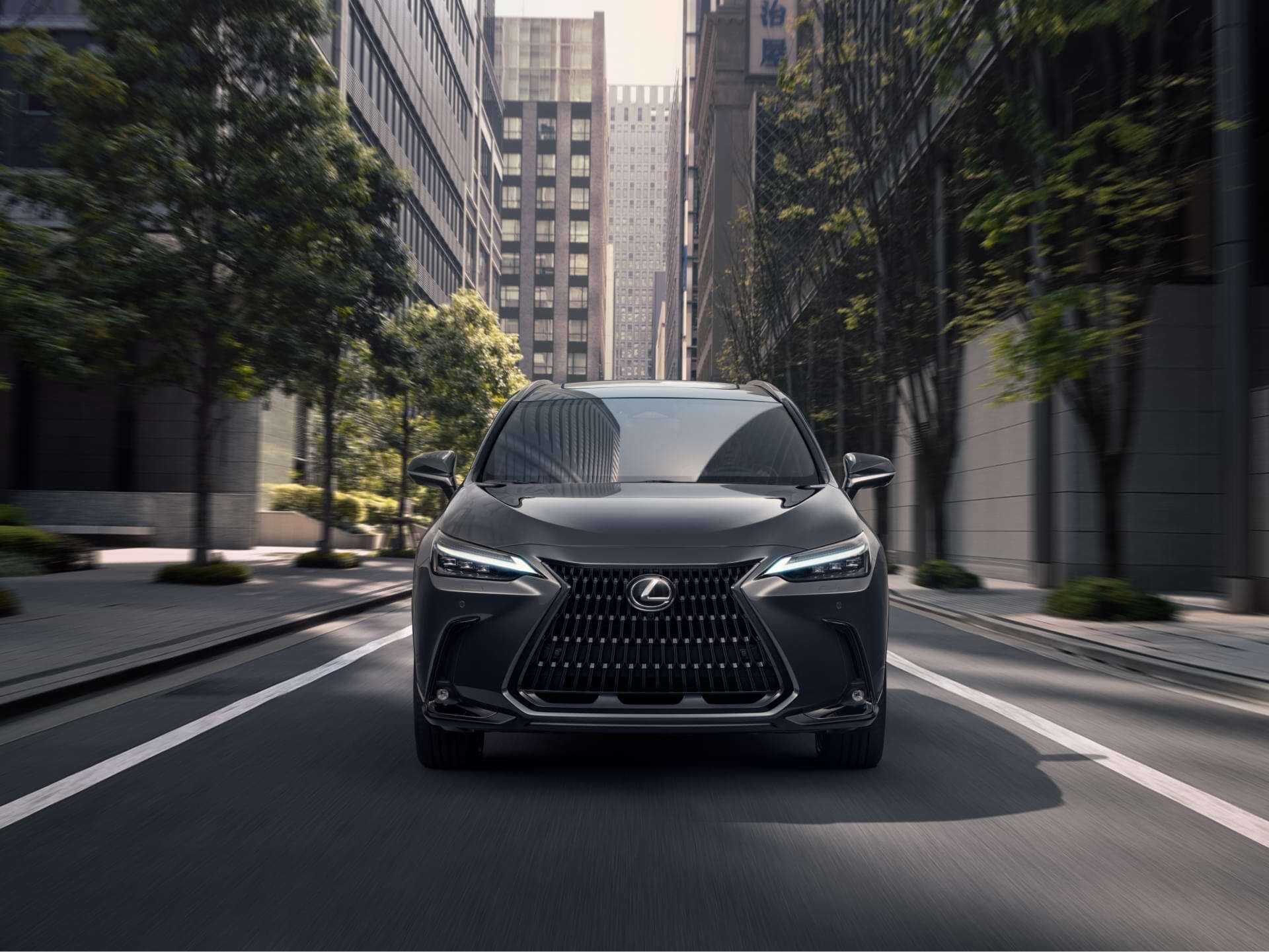 Front-on view of 2021 Lexus NX driving through a city