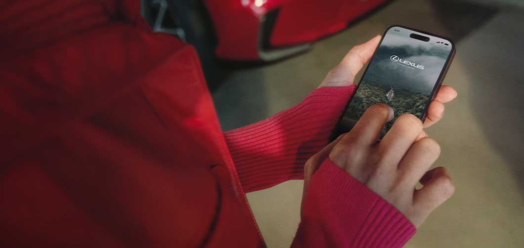 Woman holding phone with Lexus Connected App open